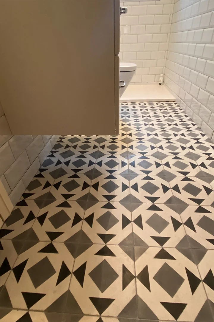 Baldosas 20x20 con motivos geométricos en suelo de baño