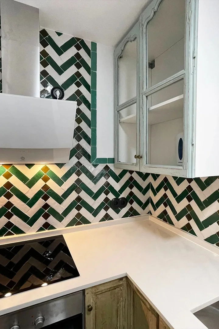 Revestimiento de cocina con piezas verdes, blancas y oscuras colocadas en espiga